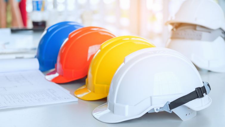 Nova Scotia Spending $100 Million Recruiting Skilled Tradespeople - a row of hard hats on a work table in a construction site.