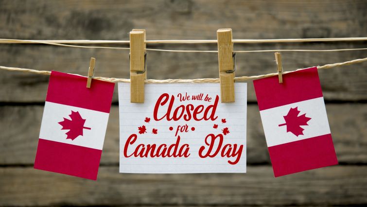 What’s Open and Closed on Canada Day - Canadian flags over a closed for Canada Day sign.
