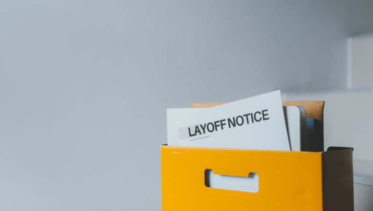 How To Handle Layoffs on Your Resume - a box with business items including a layoff notification.