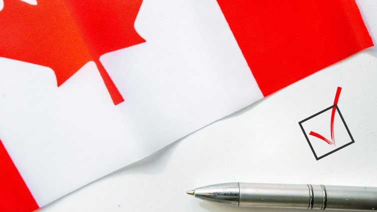 Creating a Canadian CV in 2025 - a Canadian flag with a pen and checkmark on a piece of paper.